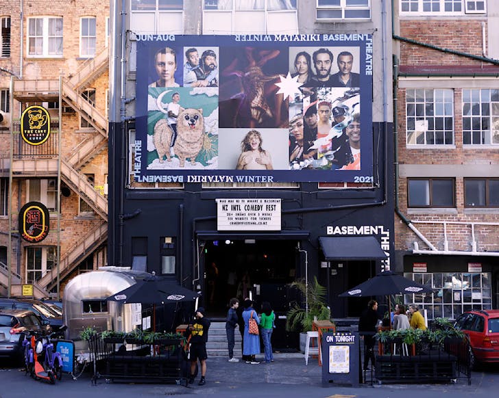 A cute theatre at the bottom of a brick building. 