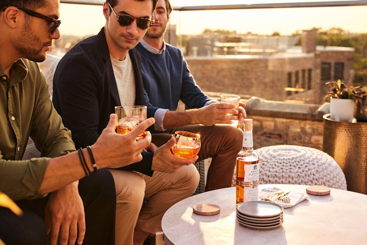Men on rooftop drinking Basil Hayden.