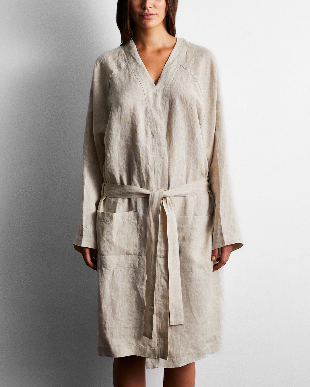 A woman wears a linen oatmeal robe. 