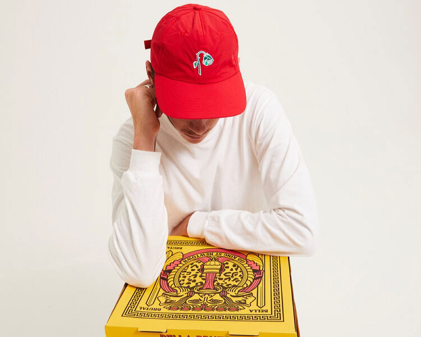 Person in red cap with pizza boxes