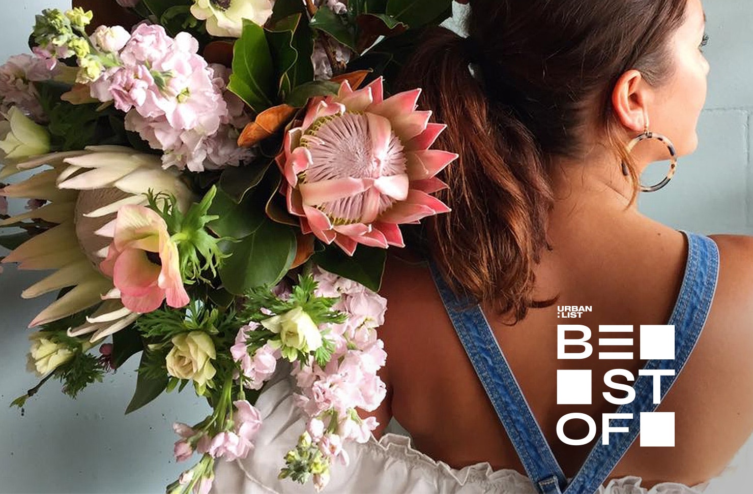 A girl holds a beautiful bouquet over her shoulder at The Botanist. One of Auckland's best flower delivery businesses.