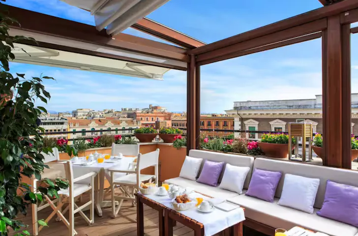 Airbnb in Rome with an outdoor dining area on a rooftop terrace with views overlooking Romeâs architecture