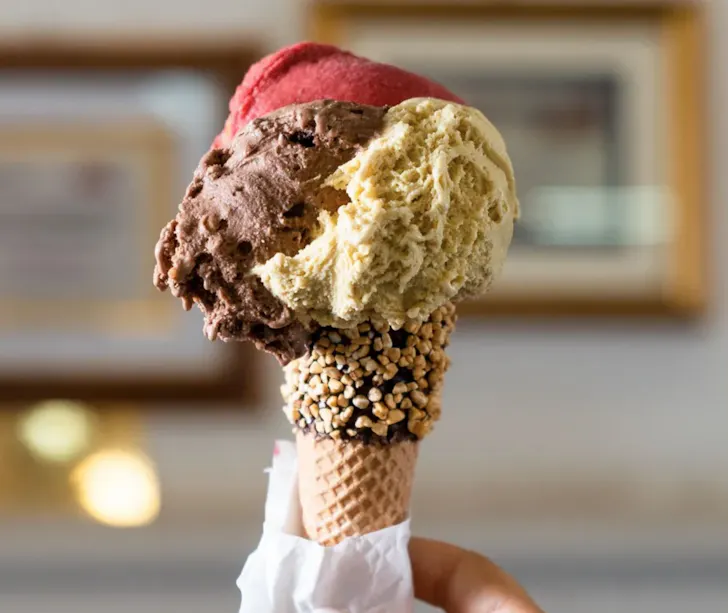 Best gelato in Rome from Gelateria Fassi with chocolate, pistachio and berry scoops in a waffle cone with chocolate and hazlenuts