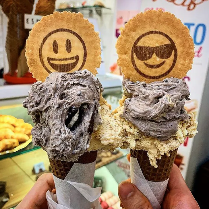 Best gelato in Rome from Gelateria Sweet Life with chocolate cookie and cream gelato cones topped with smiley face biscuit wafers