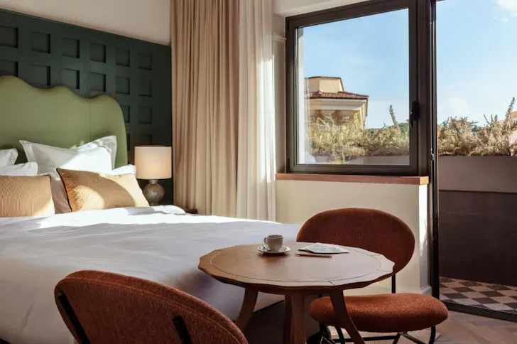 Best affordable hotels in Rome at The Hoxton Rome with stylish bedroom and terrace view