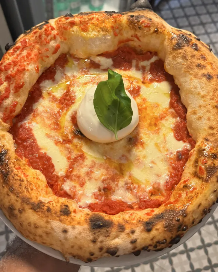 Best pizza in Rome at Piccolo Buco with a margherita pizza topped with a ball of burrata cheese