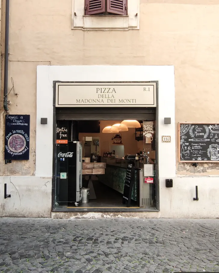 Best pizza in Rome at Pizzeria della Madonna dei Monti with the pizzeria shopfront on a cobblestone street