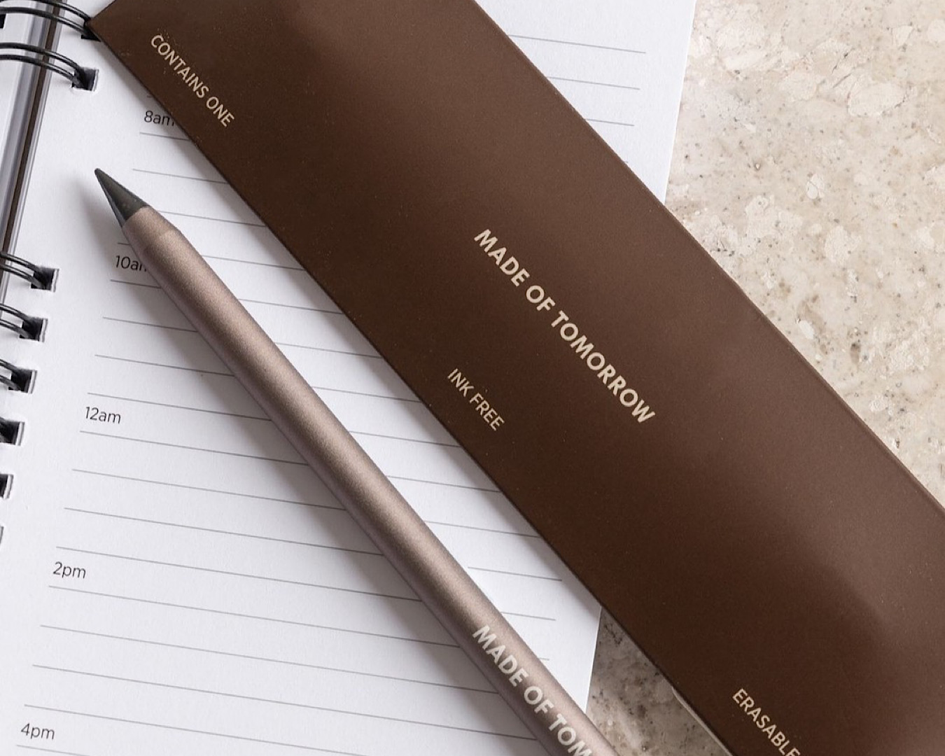 A sleek pencil sits on a notebook. 
