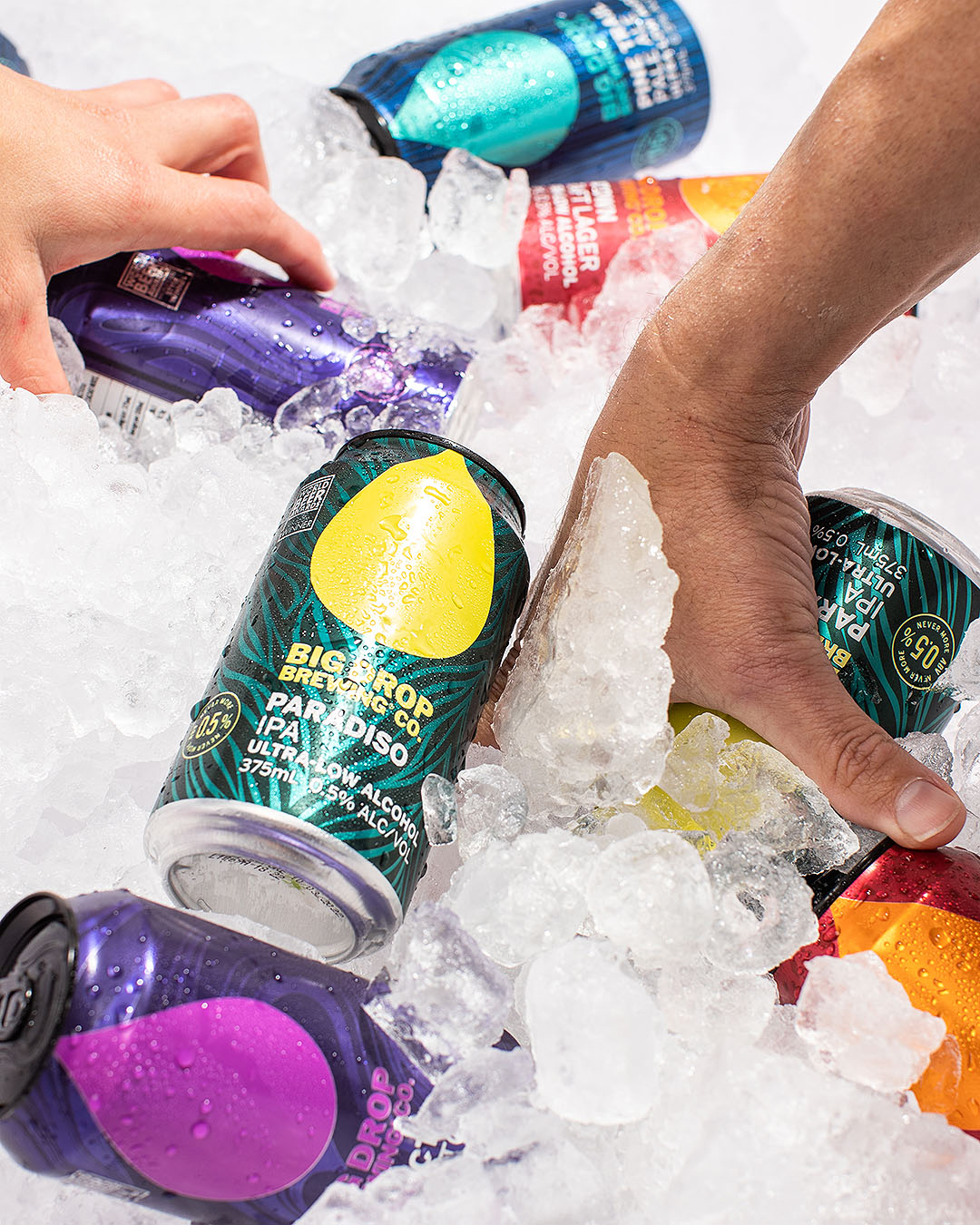 Hands dive into ice to retrieve their Big Drop Brewing beers.