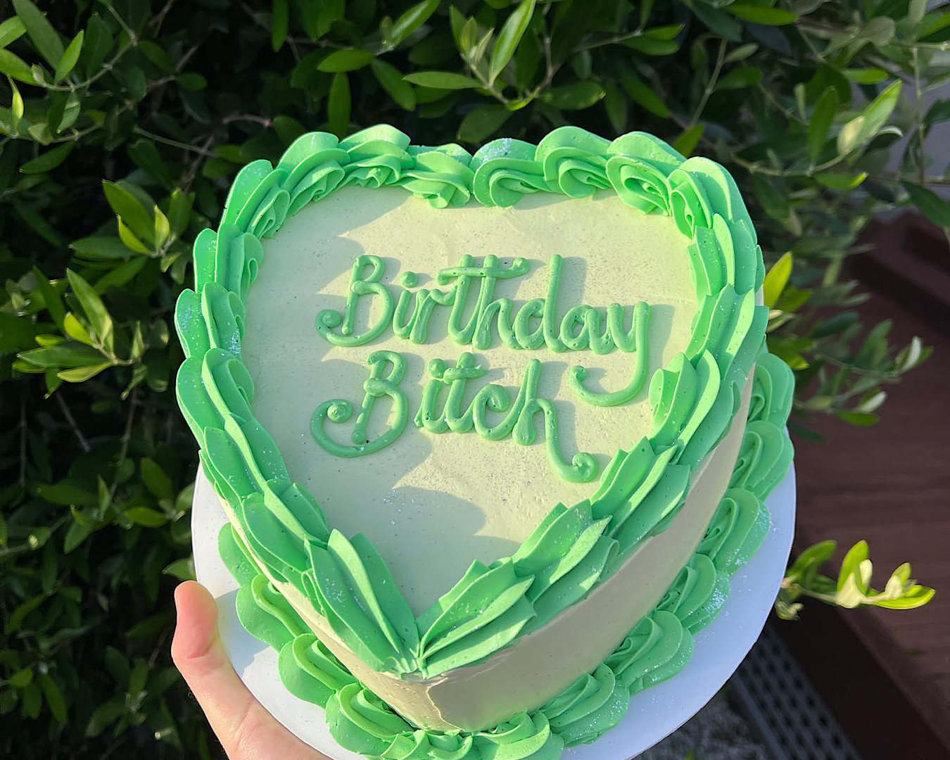 Lime green plant-based cake by Neat. with the words “Birthday Bitch” piped in icing.  