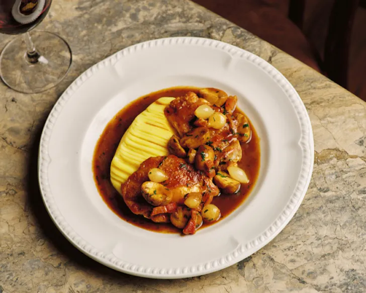A gorgeous looking dish and a glass of red wine on a marble counter at Bistro Saine. 