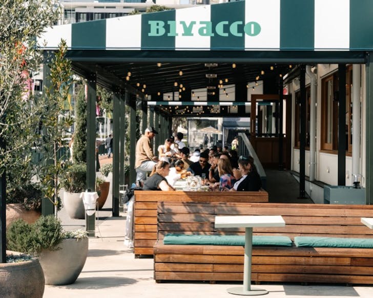 People enjoying drinks and eats in the sun at Bivacco, one of the best bars in Auckland. 