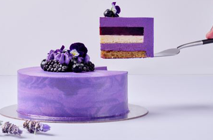 A perfectly cut piece of cake with bright purple icing from Black Star Pastry's Mothers Day in Melbourne cake 