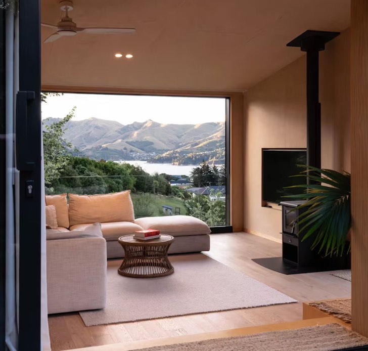 A view of the harbour through the window in the living space at Black Diamond romantic stay Christchurch, New Zealand