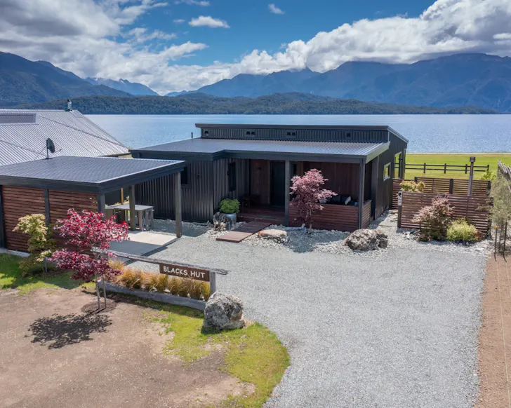 An exterior view of Black's Hut Airbnb on the lakefront NZ