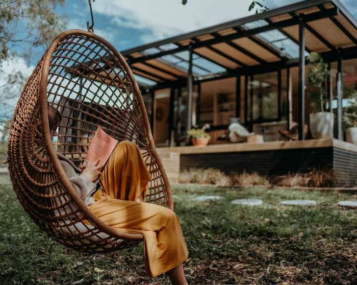 The swinging egg chair in front of Blackwood Cabin Airbnb one of the best romantic stays in New Zealand