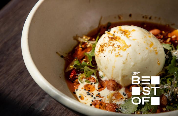A gorgeous round of burrata sitting in a bowl of chilli-spiked vegetables. 