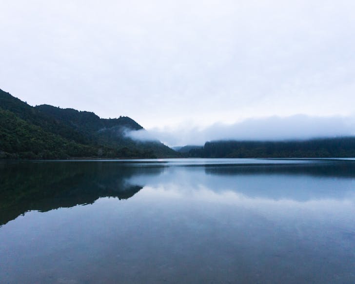 A scenic lake with a view of the clouds descending over the valley