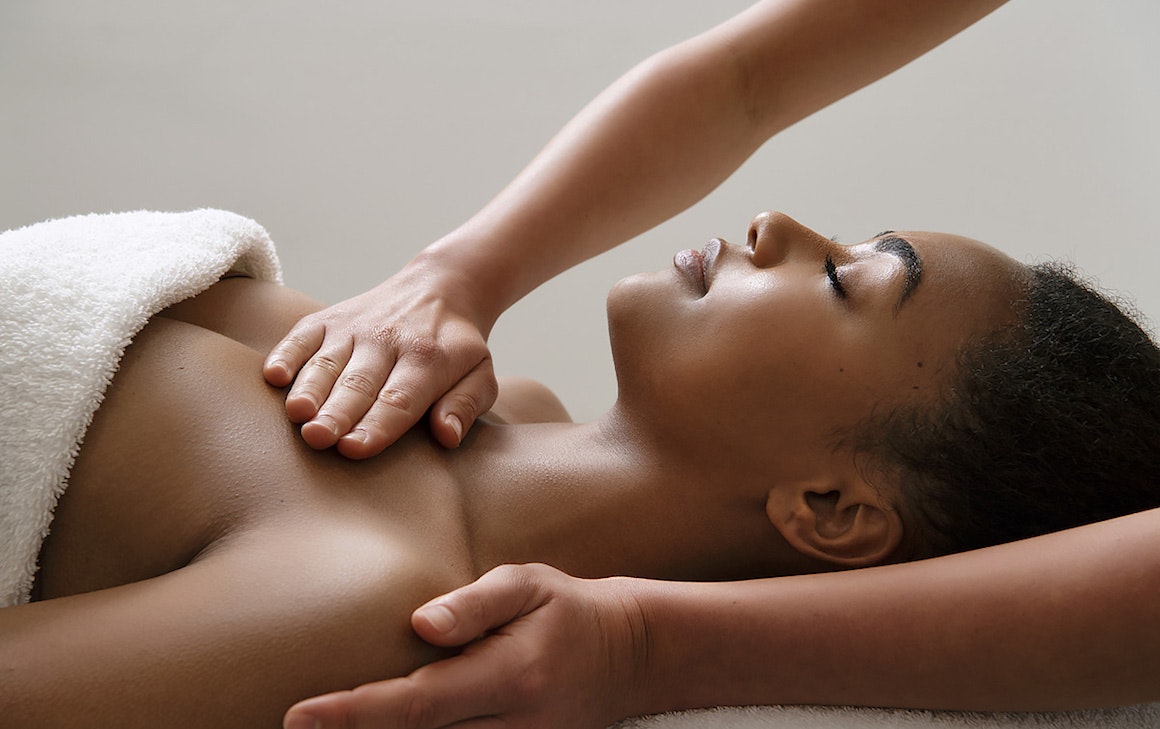 person being massaged on table in a white towel
