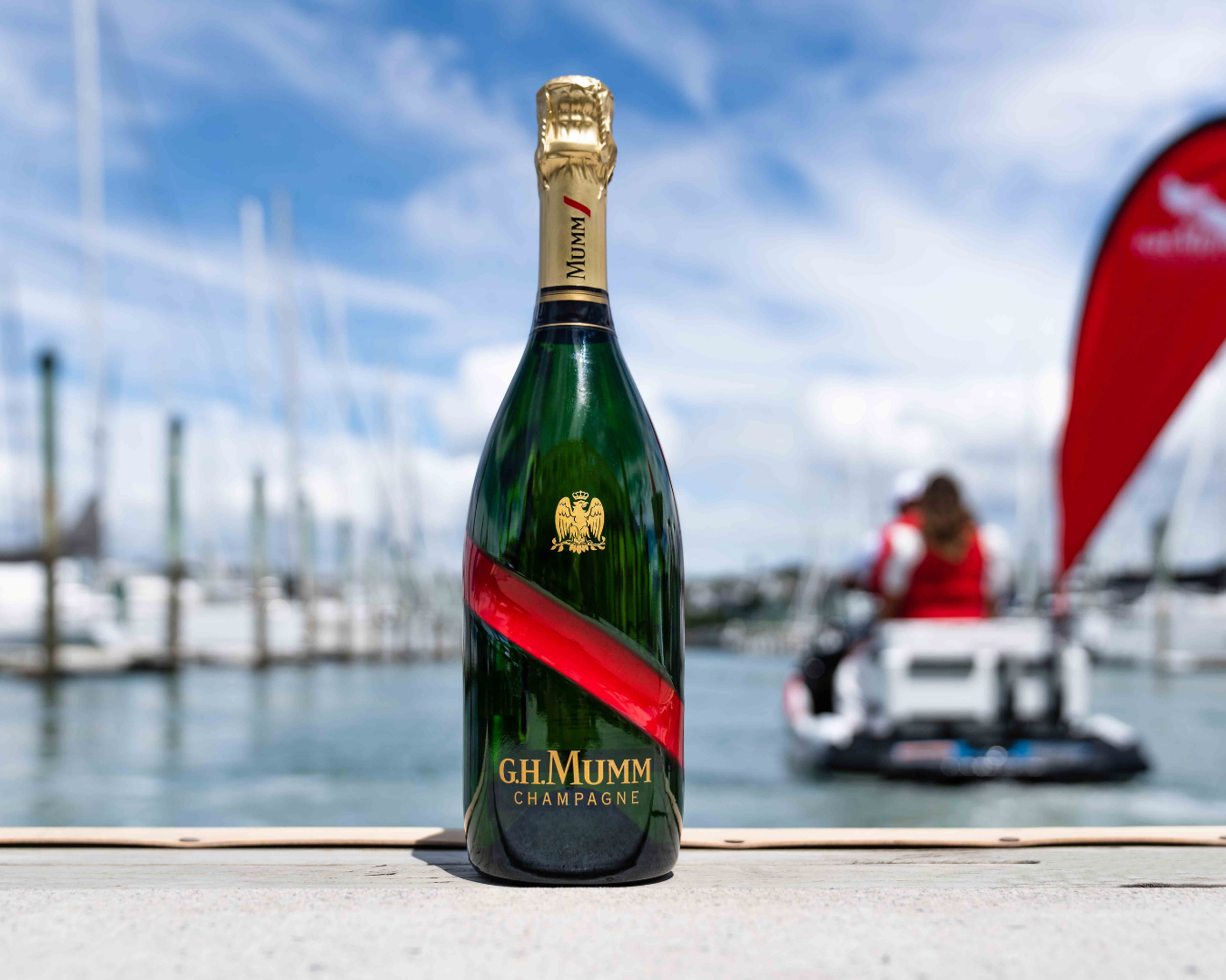 Bottle of G.H Mumm's champagne on the dock with the jet ski in the background