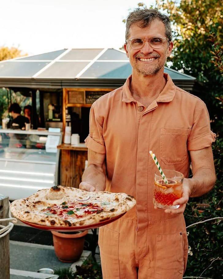 Ed Monteschio armed with pizza and a cocktail at Bomba, one of the best Italian restaurants in Christchurch. 