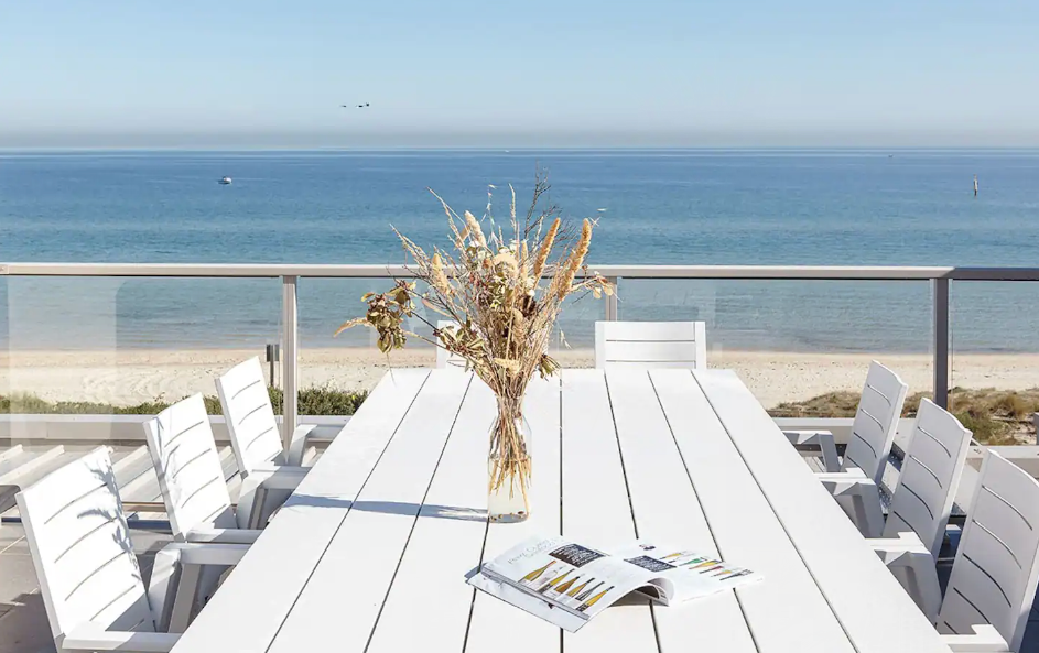 A long white table overlooking the beach at one of the best romantic getaways in Victoria. 