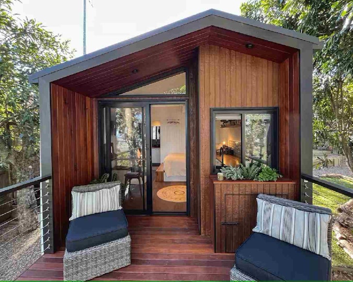 The wooden panelled exterior of Bonithion Mountain View Cabin tiny home in South East Queensland
