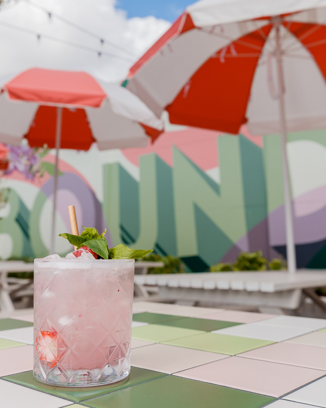 a pink cocktail on a tiled table at Boundary Hotel, a west end pub