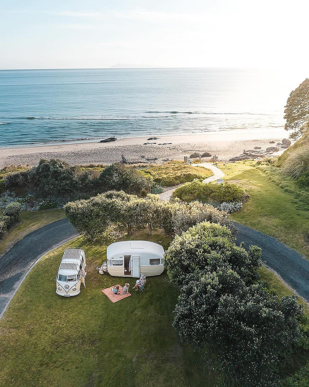 A combi and caravan pulled up at Bowentown Beach Holiday Park, one of the best camping grounds near Tauranga.
