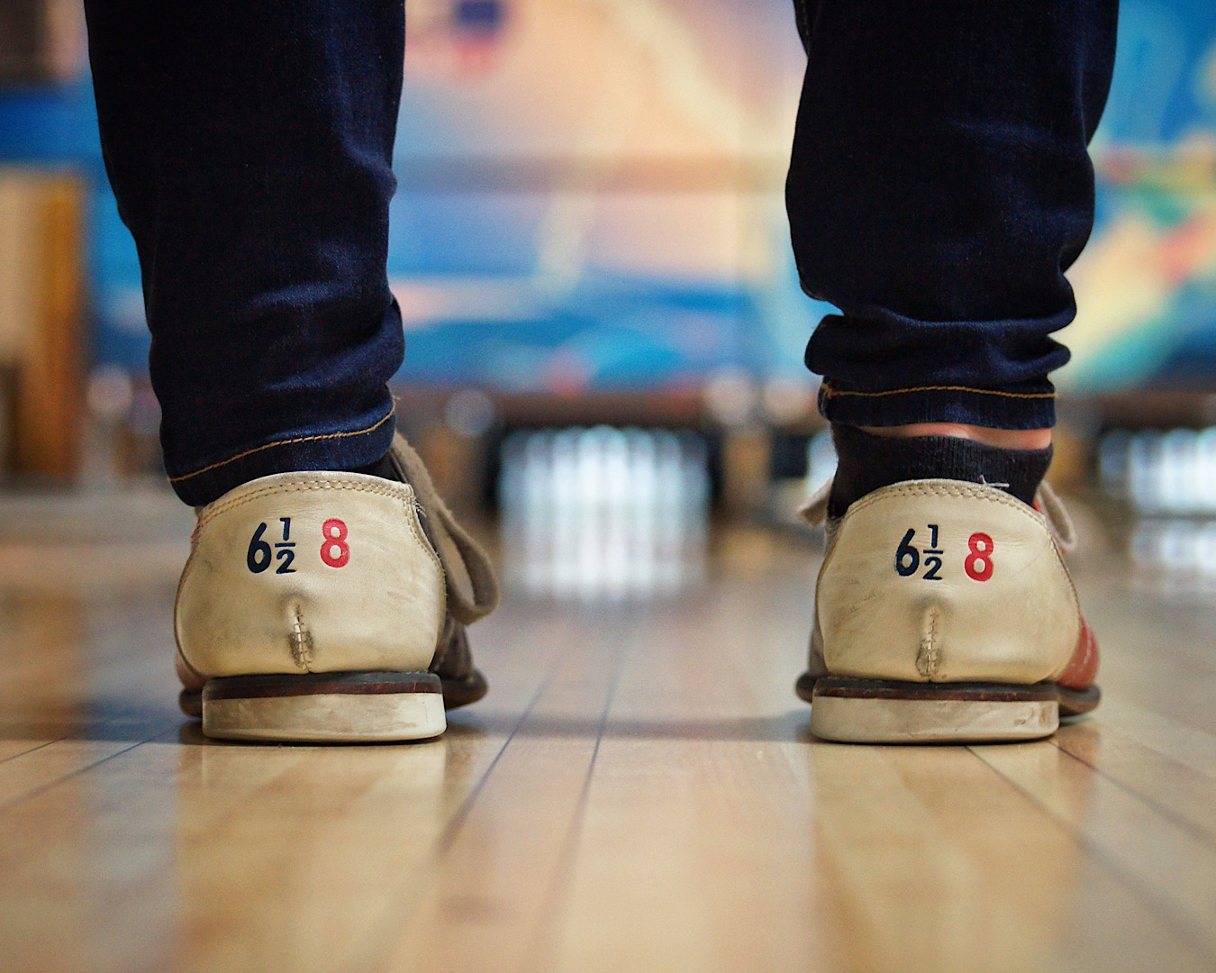 Somebody’s jean-clad legs from behind sporting the ever-fabulous typical bowling shoes in size 6.5. 