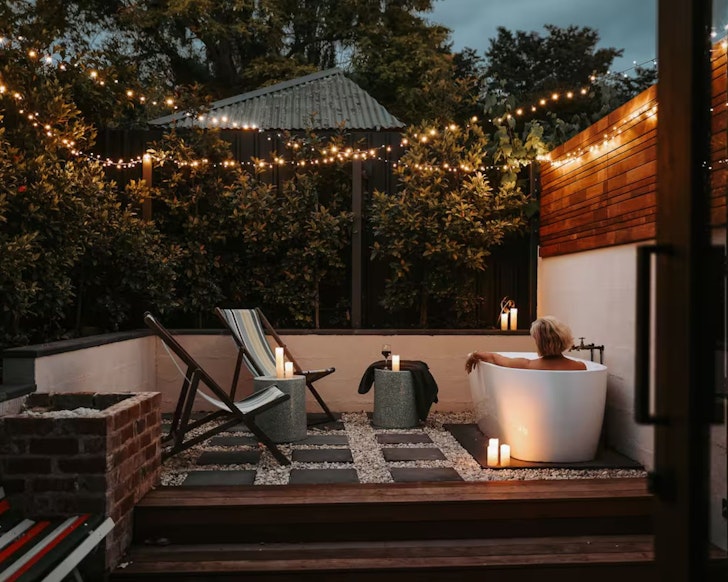 A guest relaxes in the outdoor bath at Braithwaite Hobart one of the best Hobart Airbnbs
