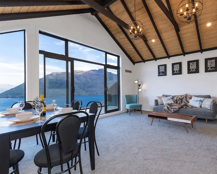 The expansive living room at this Queenstown Airbnb looks out over the lake.
