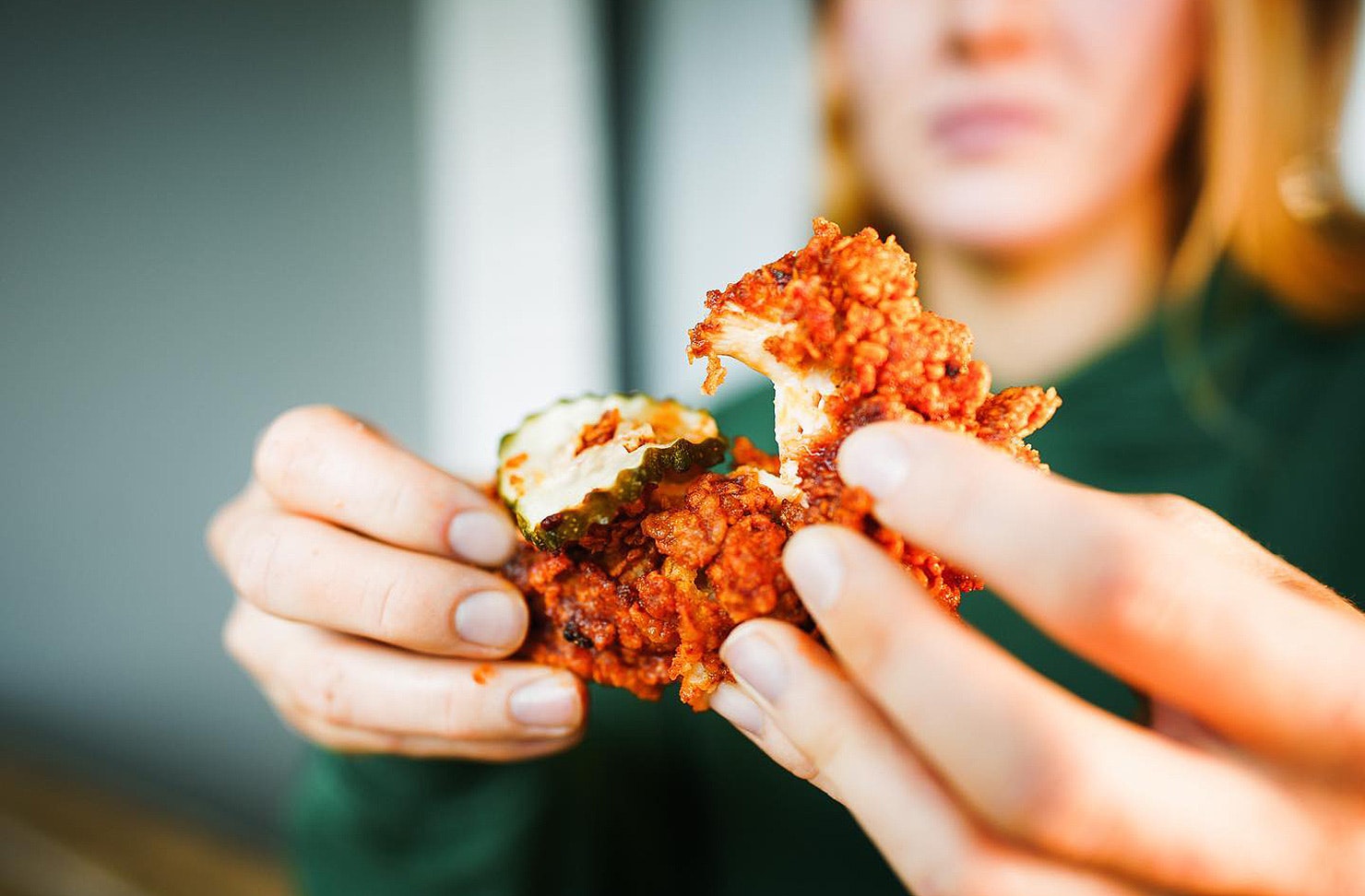 Someone pulls apart some crunchy, juicy chicken from Brew'd Hawt.