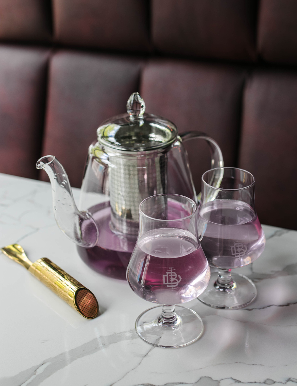 a glass teapot filled with a purple gin cocktail