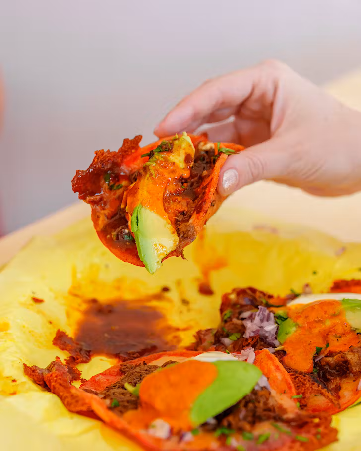 Someone holds up a handful of taco. 