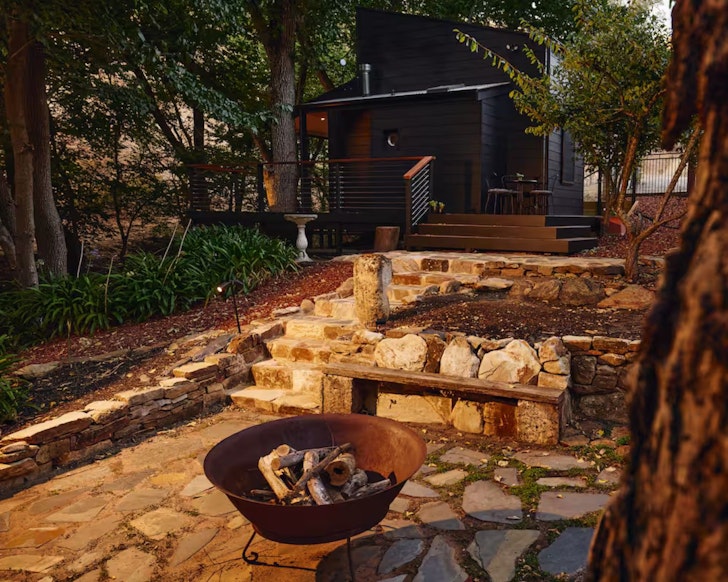 A view of the fire pit and cabin at Brownhill Creek Cabin Airbnb on of the best pet-friendly Adelaide stays