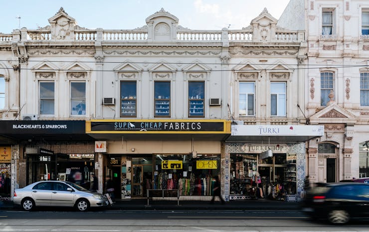 A street view of Sydney Road in Brunswick with shops and people walking.