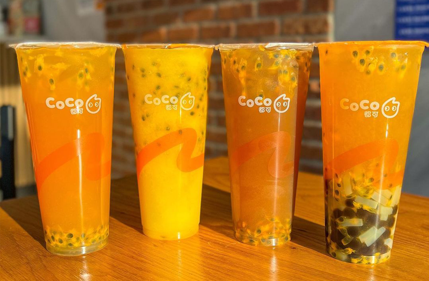 four bubble tea lined up on a shelf