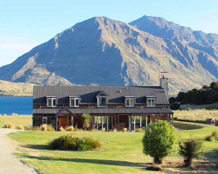 An exterior view of Buchanan Lodge one of the best accommodation options in Wanaka New Zealand with a mountain behind