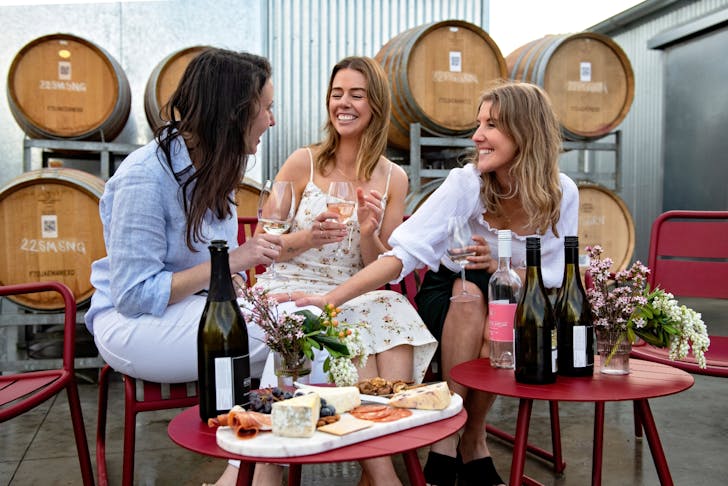 Three women drinking wine at a vineyard