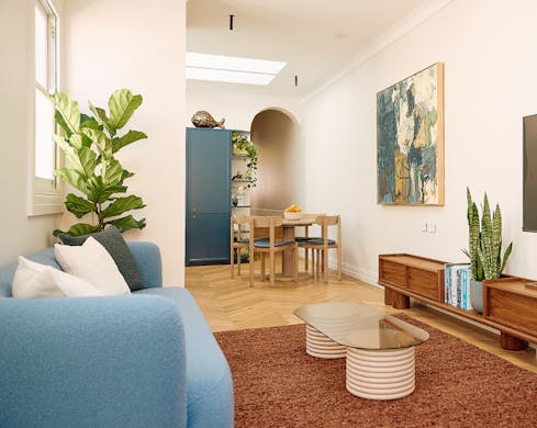 The living room of an Australia Street Suite with a blue couch, coffee table and large television
