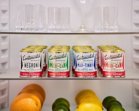 Four tinned cocktails pictured in a bar fridge