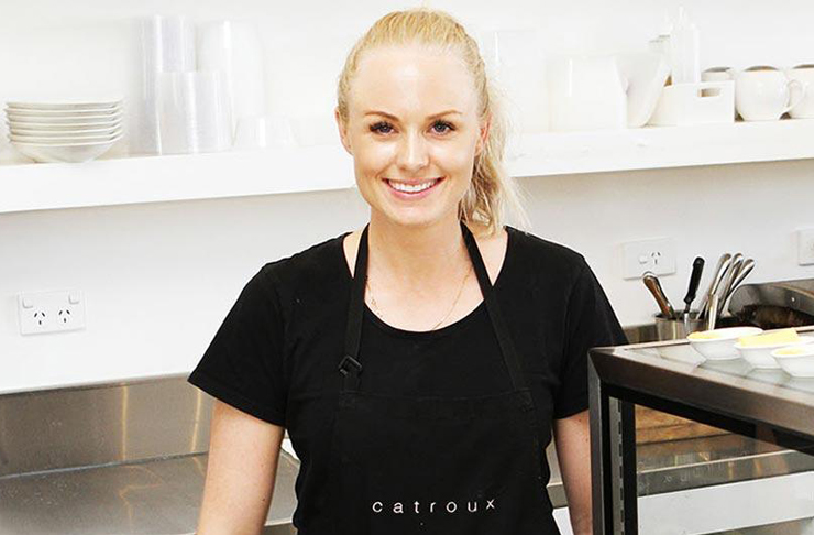 Adele of Catroux stands in the kitchen of her cafe which is white