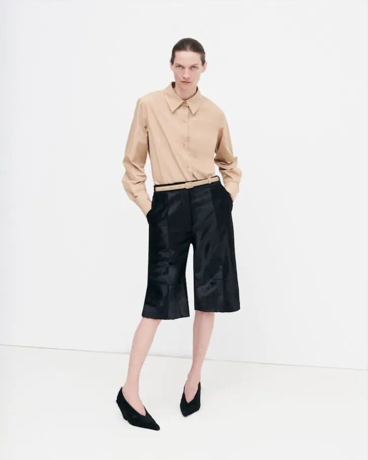 A model wears a neutral top and black over the knee shorts from Camilla And Marc one of the best Australian fashion labels