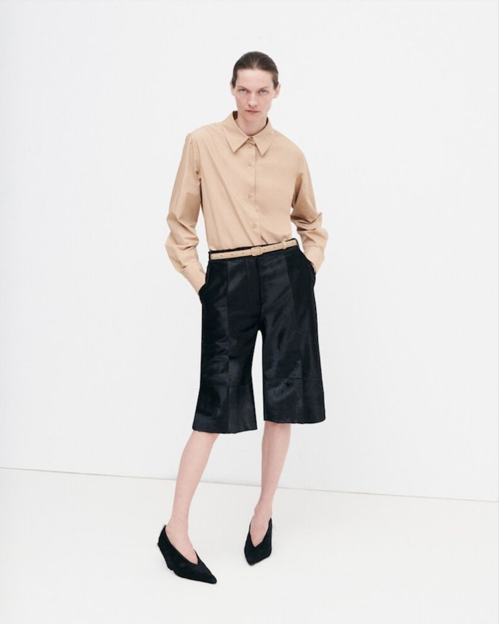 A model wears a neutral top and black over the knee shorts from Camilla And Marc one of the best Australian fashion labels