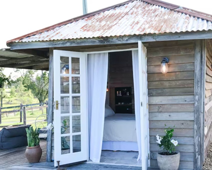 The wooden-clad exterior of Capaja Creamery one of the best tiny home stays in South East Queensland