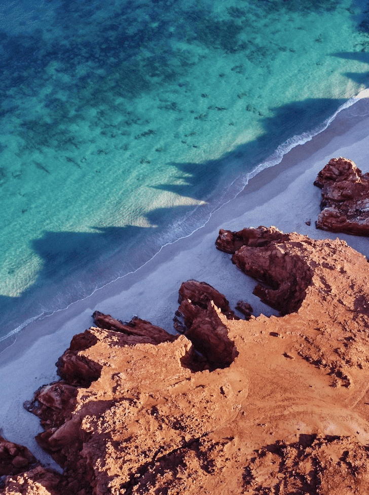 A red dessert meets vibrant turquoise waters. 