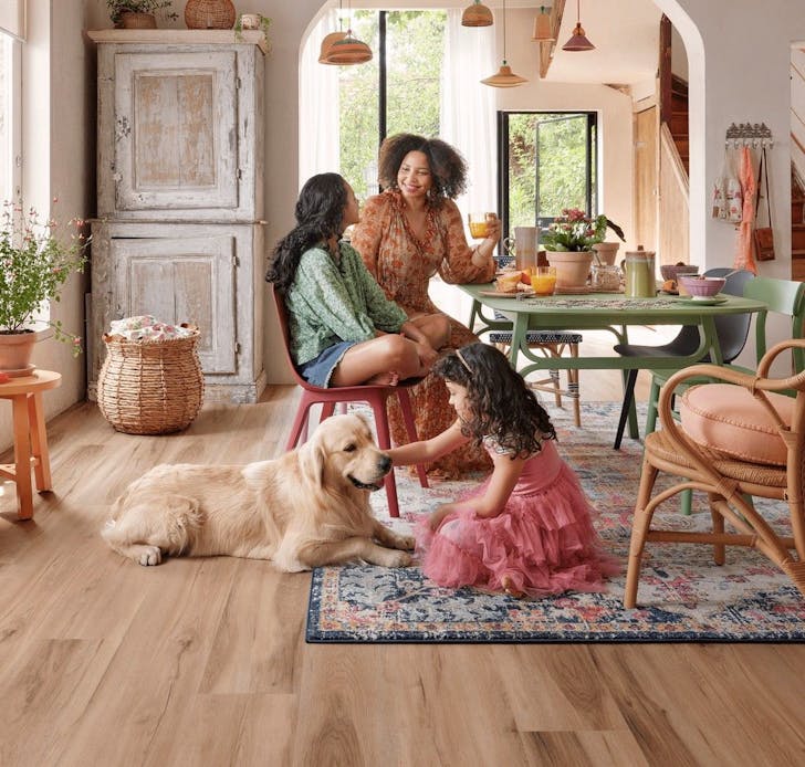 A family sits around a table with a dog in a beautiful home