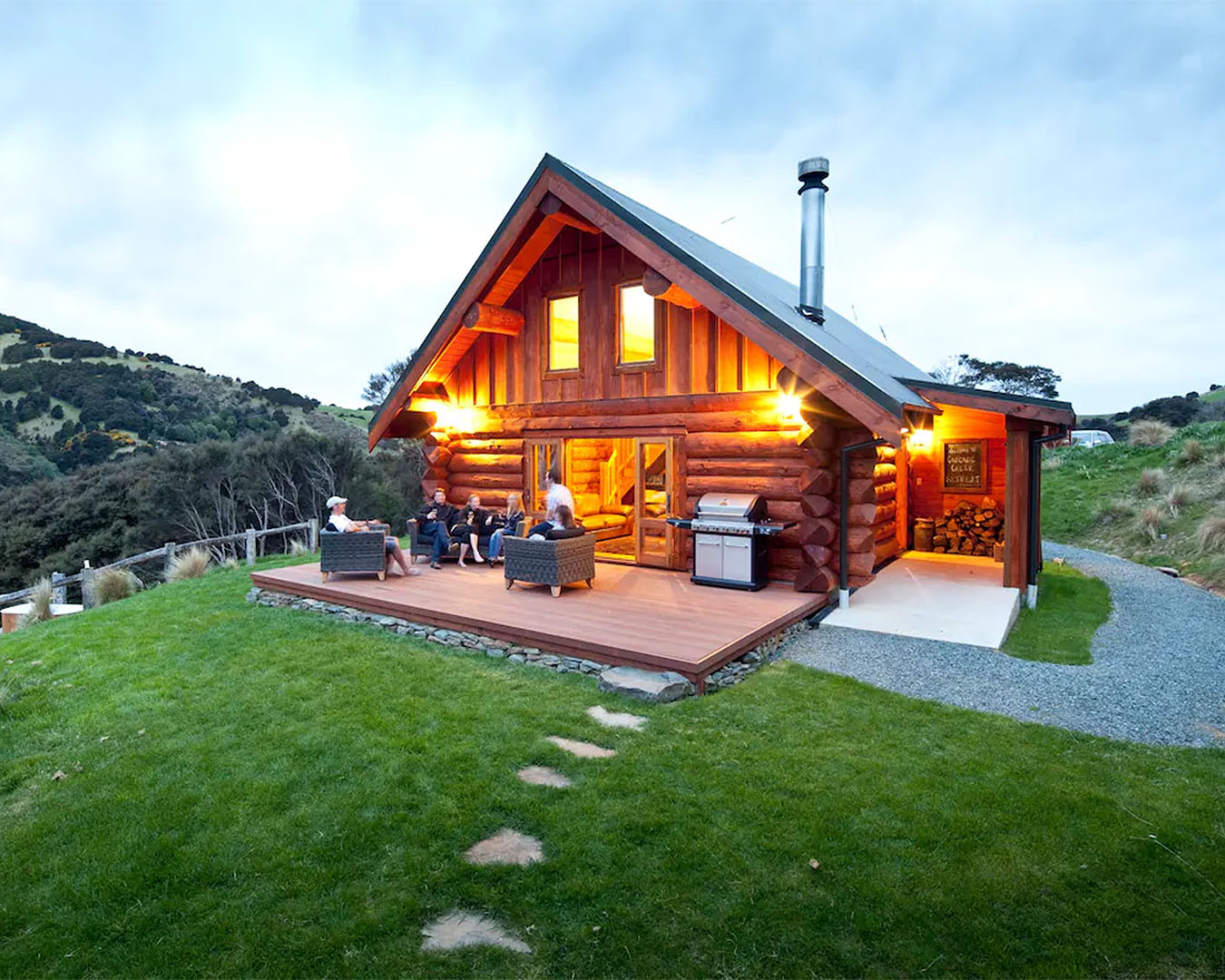 Cascade Creek Retreat is seen from the outside with people relaxing on the deck.