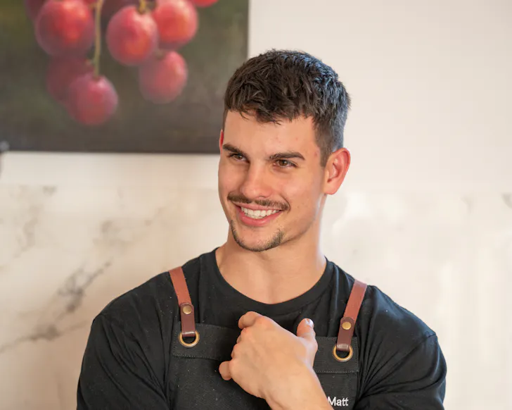 Chef Matt Mirosevich smiles at the camera in his catering apron.